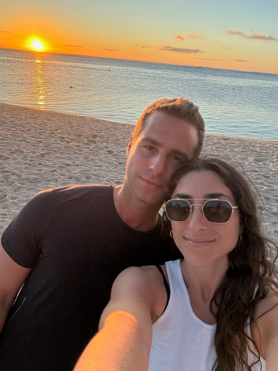 Brandon and Nikki together on a beach at sunset